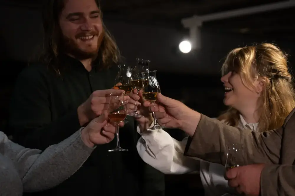 Personer skåler med akevitt i glasset.