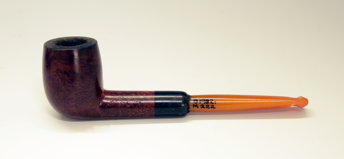 Pipe i etui. Brunt hode, gult munnstykke. Stemplet "Lillehammer G.L.". Etuiet stemplet "G. Larsen. Pipefabrik Lillehammer."
