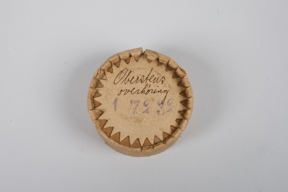 Fonografrull i svart materiale. Eske i papp med avtagbart lokk. Tekst om innholdet på lokket.