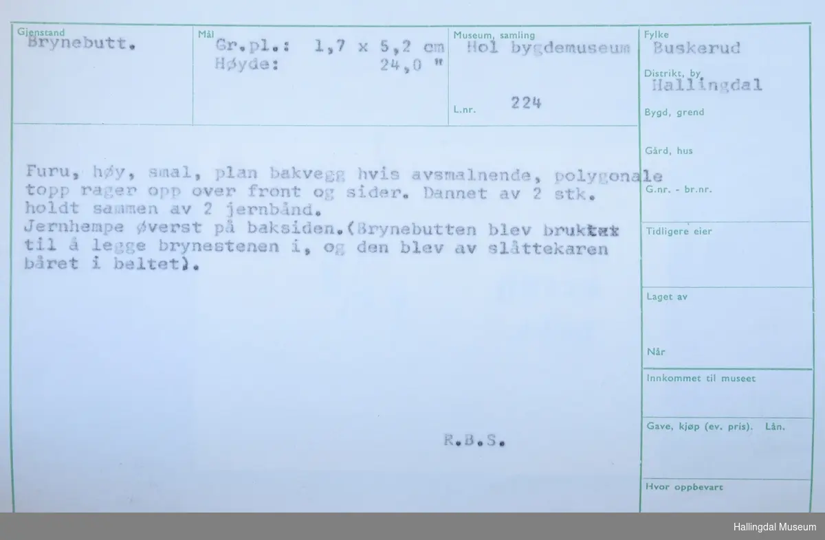 Furu, høy, smal, plan bakvegg hvis avsmalnende, polygonale topp rager opp over front og sider. Dannet av 2 stk. holdt sammen av 2 jernband.
Jernhempe øverst på baksiden. (Brynebutten blev brukter til å legge brynestenen i, og den blev av slåttekaren båret i beltet).
Gr.pl.: 1,7x5,2 cm
Høyde: 24 cm

R.B.S.