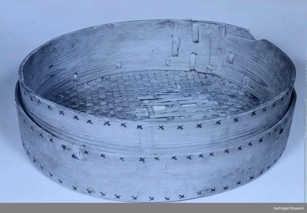 Tre, rundt. Vertikal side dannet av ett bøyd stykke, bunnen laget av smale, flettede bånd, fastholdt til veggen ved utv. flatt, bredt trebånd.

(Benyttet på Søndre Berg i Hovet, Hol). Veggens utside prydet med små svidde kors. Bunnen defekt.
Diam: 40 cm, Høyde: 10,9 cm.
R.B.S.