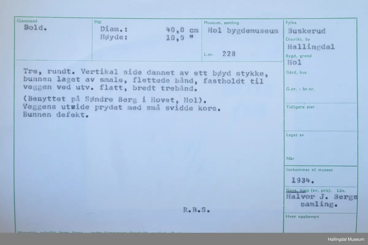 Tre, rundt. Vertikal side dannet av ett bøyd stykke, bunnen laget av smale, flettede bånd, fastholdt til veggen ved utv. flatt, bredt trebånd.

(Benyttet på Søndre Berg i Hovet, Hol). Veggens utside prydet med små svidde kors. Bunnen defekt.
Diam: 40 cm, Høyde: 10,9 cm.
R.B.S.