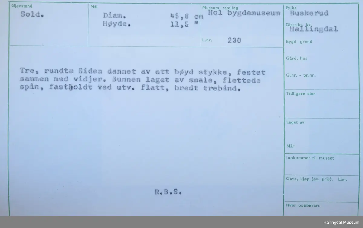 Tre, rundt. Siden dannet ett bøyd stykke, festet sammen med vidjer. Bunnen laget av smale, flettede spon, fastholdt ved utv. flatt, bredt trebånd.
R.B.S.