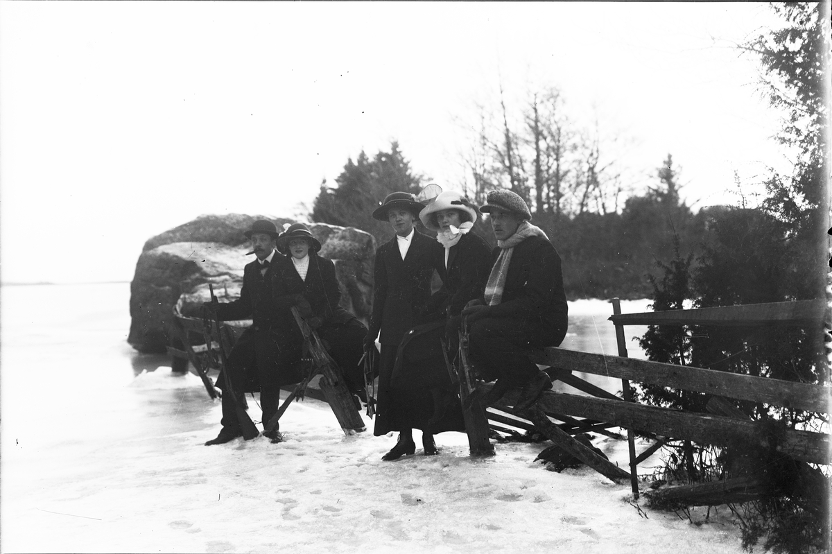 Kvinnor och män med skridskor vid isen, Östhammar, Uppland