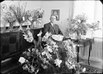 Elmontör Valdemar Johansson omgiven av blommor, Gimo, Uppland