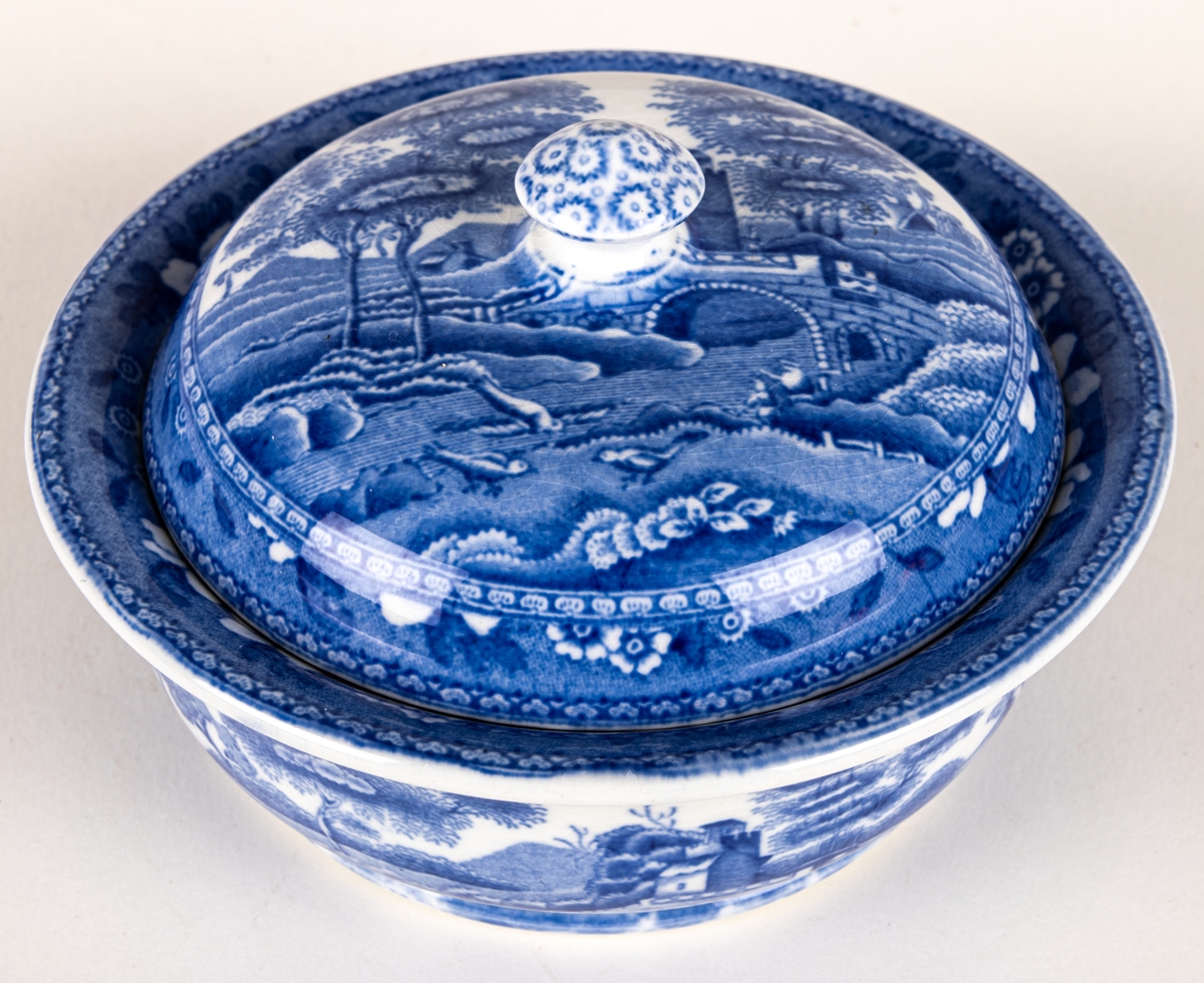 Tvålkopp i tre delar, kopp, insats, lock.
Stämpel: Copeland Spodes Tower England.
Dekor: Blått mönster. Blombård. Landskapsmotiv.