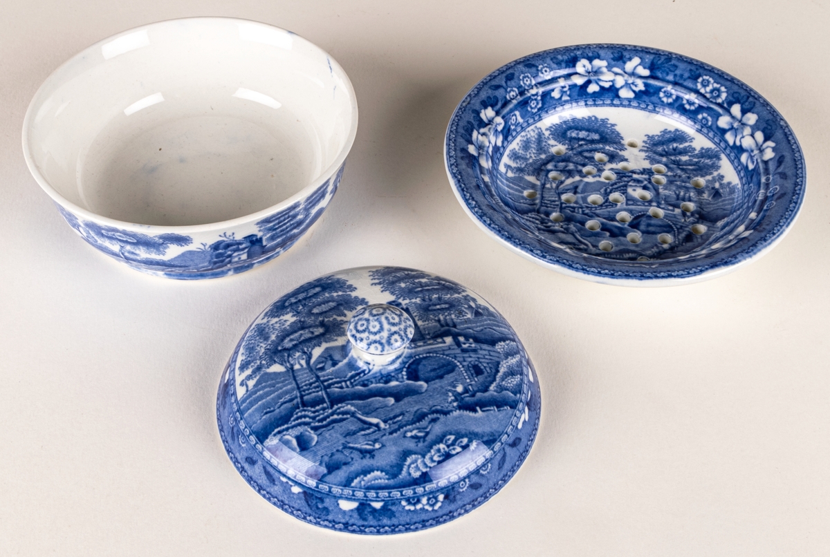 Tvålkopp i tre delar, kopp, insats, lock.
Stämpel: Copeland Spodes Tower England.
Dekor: Blått mönster. Blombård. Landskapsmotiv.