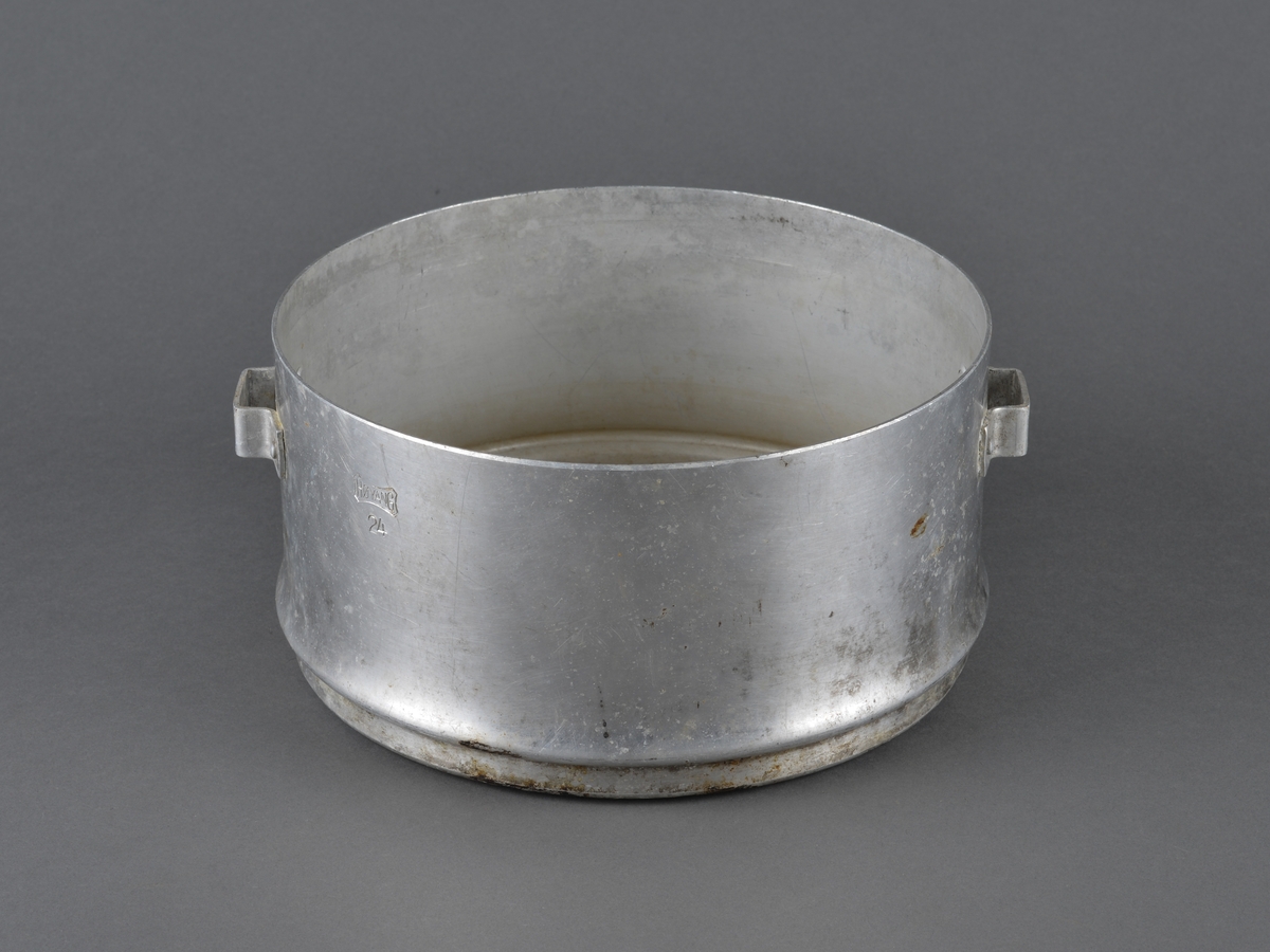 Kokerar i aluminium med hanker i sidene. 
Har trolig vært brukt til koking av vann og/eller mat.
Mangler lokk