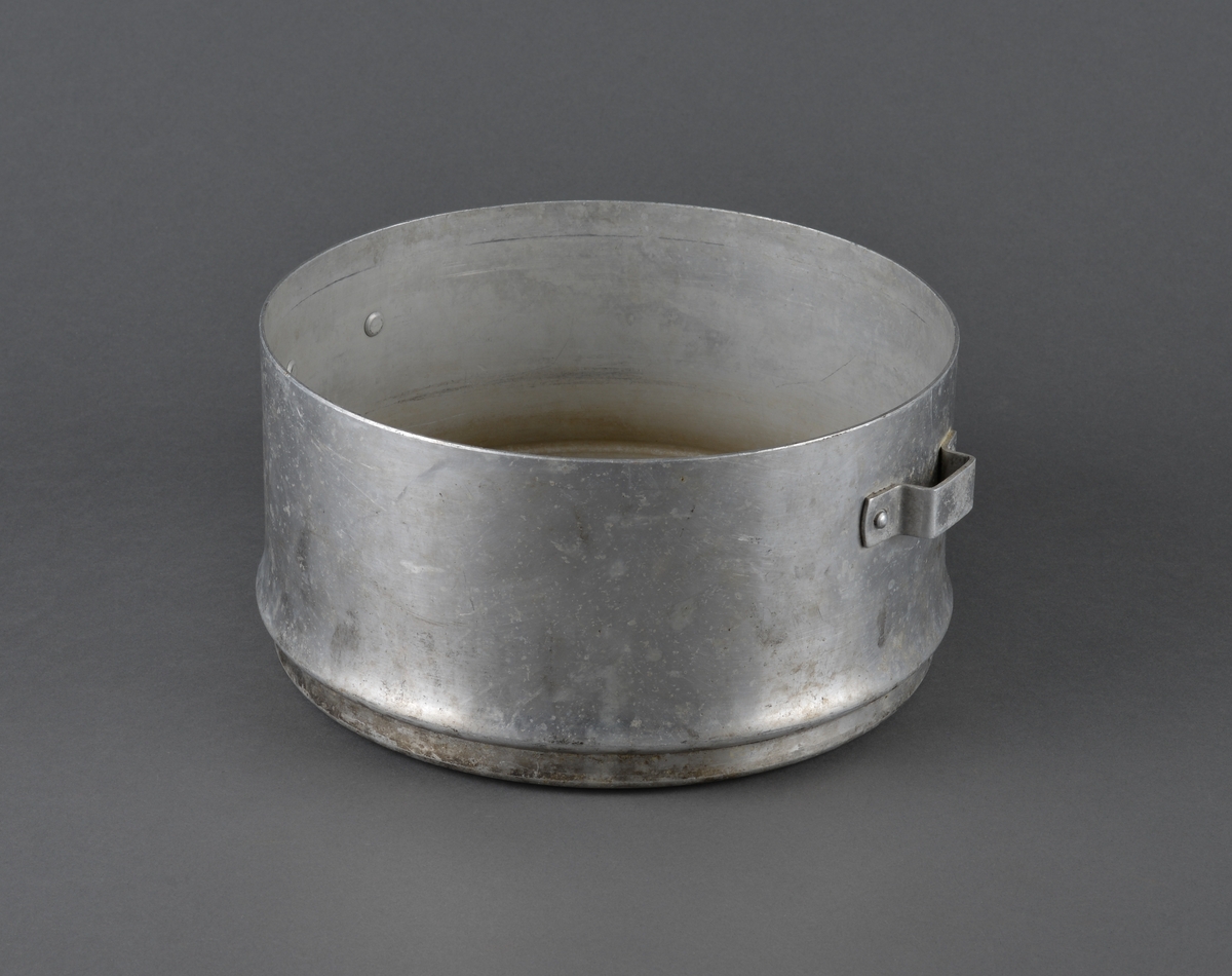 Kokerar i aluminium med hanker i sidene. 
Har trolig vært brukt til koking av vann og/eller mat.
Mangler lokk