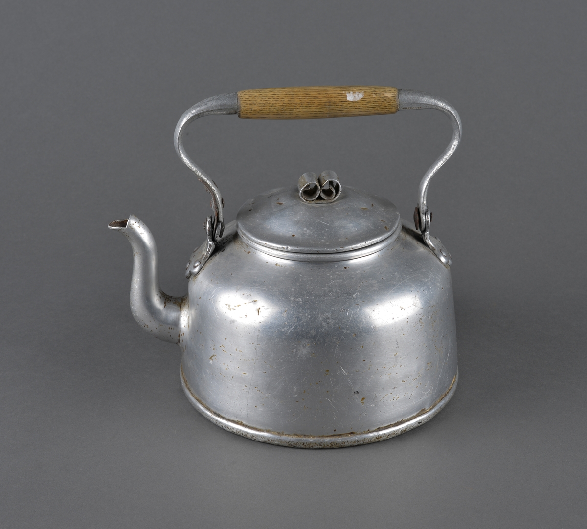 Kjele brukt til kaffekoking.
Dekor på lokket i form av to krøller, som fungerer som håndtak for å løfte av lokket. Antatt at dette er reparasjon for å erstatte opprinnelig håndtak.
Håndtaket for å løfte kjelen har midtdel av trevirke.