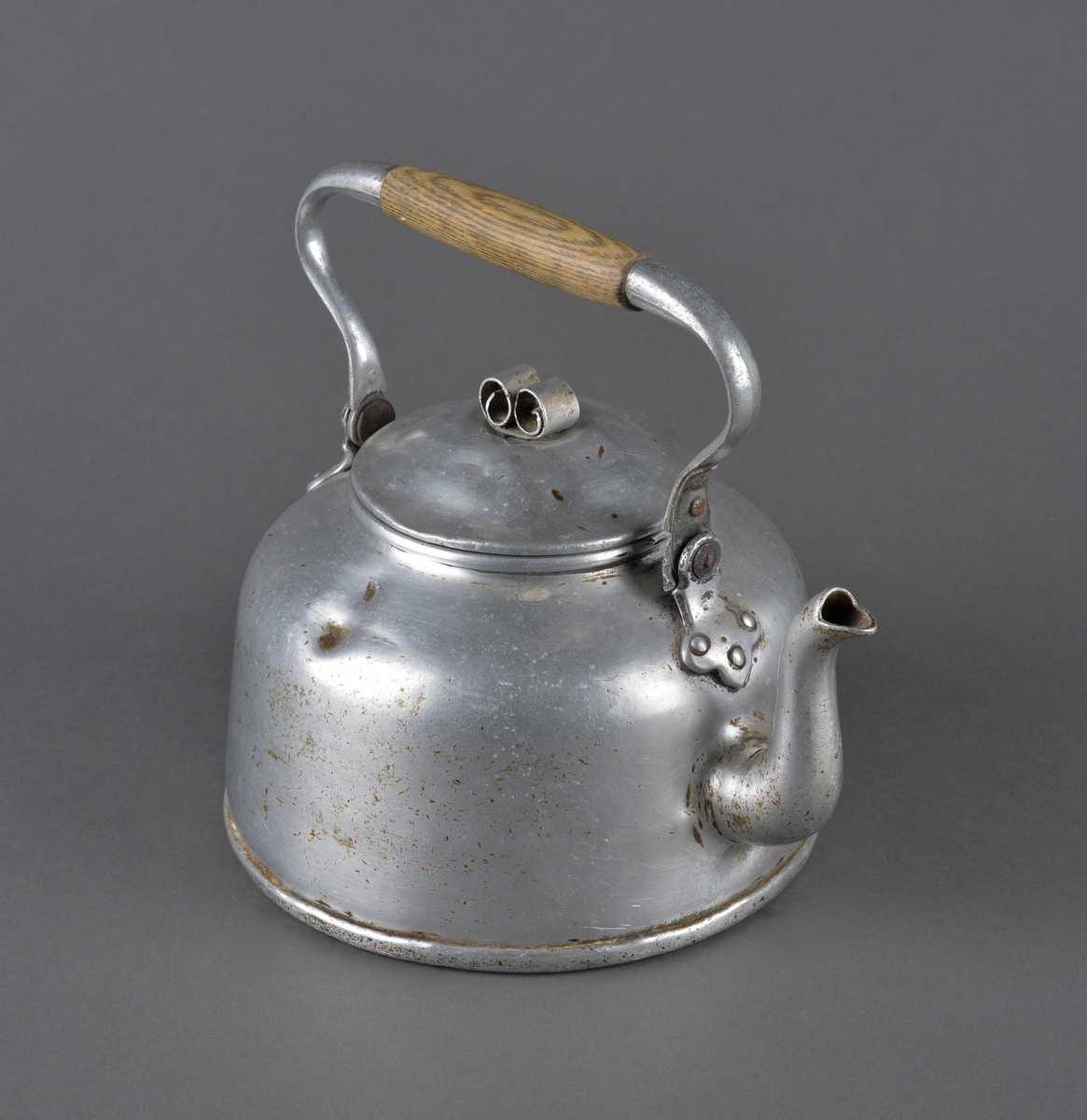 Kjele brukt til kaffekoking.
Dekor på lokket i form av to krøller, som fungerer som håndtak for å løfte av lokket. Antatt at dette er reparasjon for å erstatte opprinnelig håndtak.
Håndtaket for å løfte kjelen har midtdel av trevirke.