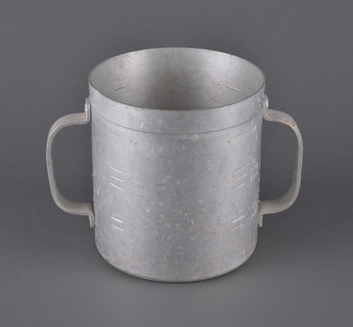 Målebeger for sild og brisling. Laget i aluminium (antatt) med måleskala på innside og utside. Tra totalt 5 liter. Handtak i sidene.

Spor av rist fra sild og brisling igjen på måleenhetens utside

Brukt av Fiskerisjefen i Sør-Trøndelag