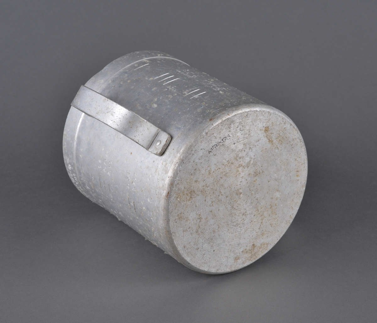 Målebeger for sild og brisling. Laget i aluminium (antatt) med måleskala på innside og utside. Tra totalt 5 liter. Handtak i sidene.

Spor av rist fra sild og brisling igjen på måleenhetens utside

Brukt av Fiskerisjefen i Sør-Trøndelag