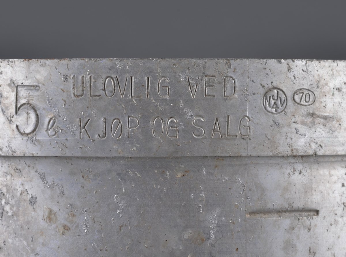 Målebeger for sild og brisling. Laget i aluminium (antatt) med måleskala på innside og utside. Tra totalt 5 liter. Handtak i sidene.

Spor av rist fra sild og brisling igjen på måleenhetens utside

Brukt av Fiskerisjefen i Sør-Trøndelag