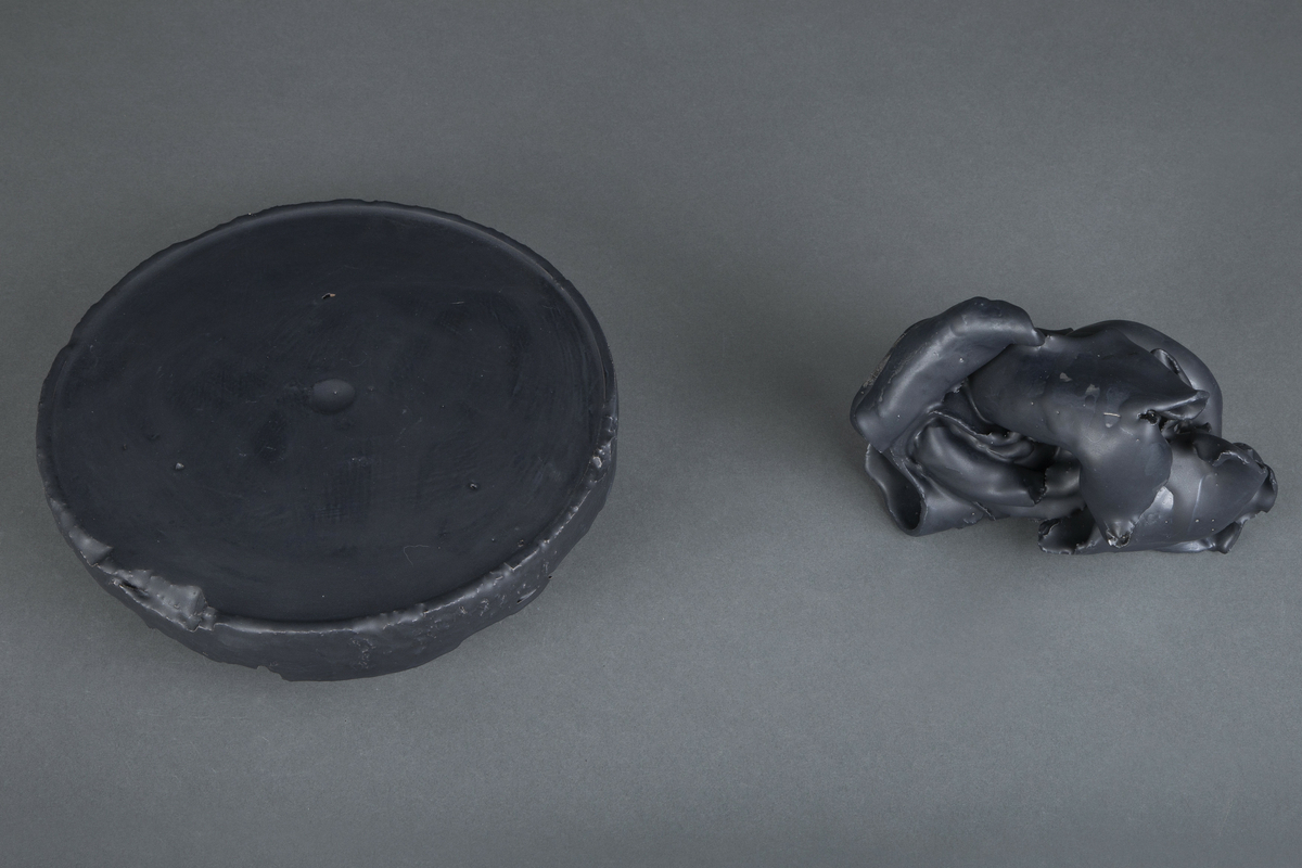 Skulptur i 2 deler hvorav den ene utgjør en slags «sokkel» og den andre utgjør «skulpturen» som hviler på sokkelen. «Sokkelens» diameter tilsvarer bunnen på en 10 liters vannbøtte, der kunstneren kaster leirerester og som blandet med vann kan lage slipp eller resirkuleres. Den øverstedelen kan tolkes som den er laget av sammenkrøllede leirerester.