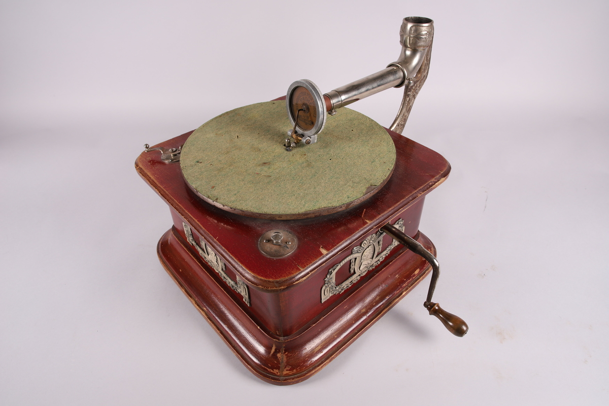 Pathéfon avspiller i treverk med finér. Sveiv på høyreside. Trakt i finér/treverk, med tynt lag av metall mellom lagene. Trakten kan løsnes fra instrumentet.