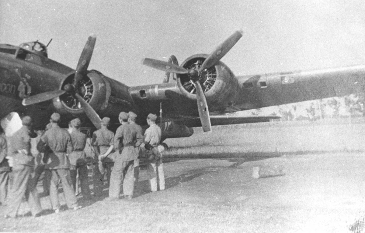 Söndagsledigt sommaren 1942. Soldater ur 7. stridsvagnskompaniet från Skaraborgs regemente beskådar en Boeing B-17 "Flying Fortress" vid Rinkaby, Skåne. Detta plan har skadats vid nattligt anfall mot Berlin.