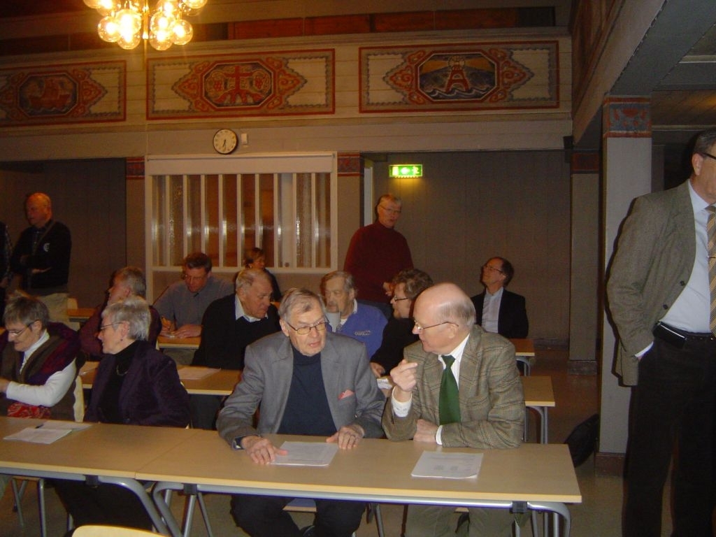 Arkelog Tony Axelsson håller föredrag om utgrävningarna i Varnhem vid GMV's årsmöte i soldathemmet 20100223.  Solbritt Jönerblad, Karin Johansson, Ulf Floberg. Längst bak står Östen Kvarnlöf.