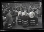 Kvinnor och män på en uteservering sittande på tunnor.