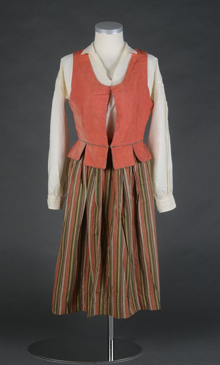 Tre-delt bunad:
A: Rødt liv med grønne kanter og hvitt bomulls fòr. Snittet er likt det som brukes til trønderbunaden. Skjøteliv med påsydd kappe og firkantete fliker i framkant. Det er sydd tittekant av grønt bomullstoff i livet og langs nedrekanten av skjøtet. Metallhekter til lukking.
B: Stakk av stripet bomullstoff i fargene brunt, rødt, gult, grønt og hvitt. Svakt rynket til linning. Lukkes med hekter og sekundært innsydd glidelås.
C: Stakk av samme snit og materiale som B. Linning med langsgående striper. Lukkes med hekter og tre trykknapper.
D: Skjorte i bomullstoff i primærsnitt. Påsydde skulderstykker, ståkrage og halssplitt med regels. Ermene er rynket til mansjetten. Mansjettene er brodert på grovere bomullstoff (sultan) med hardangersøm. Lukkes med metallhekter i messing.
Bunaden er i hovedsak maskinsydd. Som type er den trolig fra mellomkrigstida.