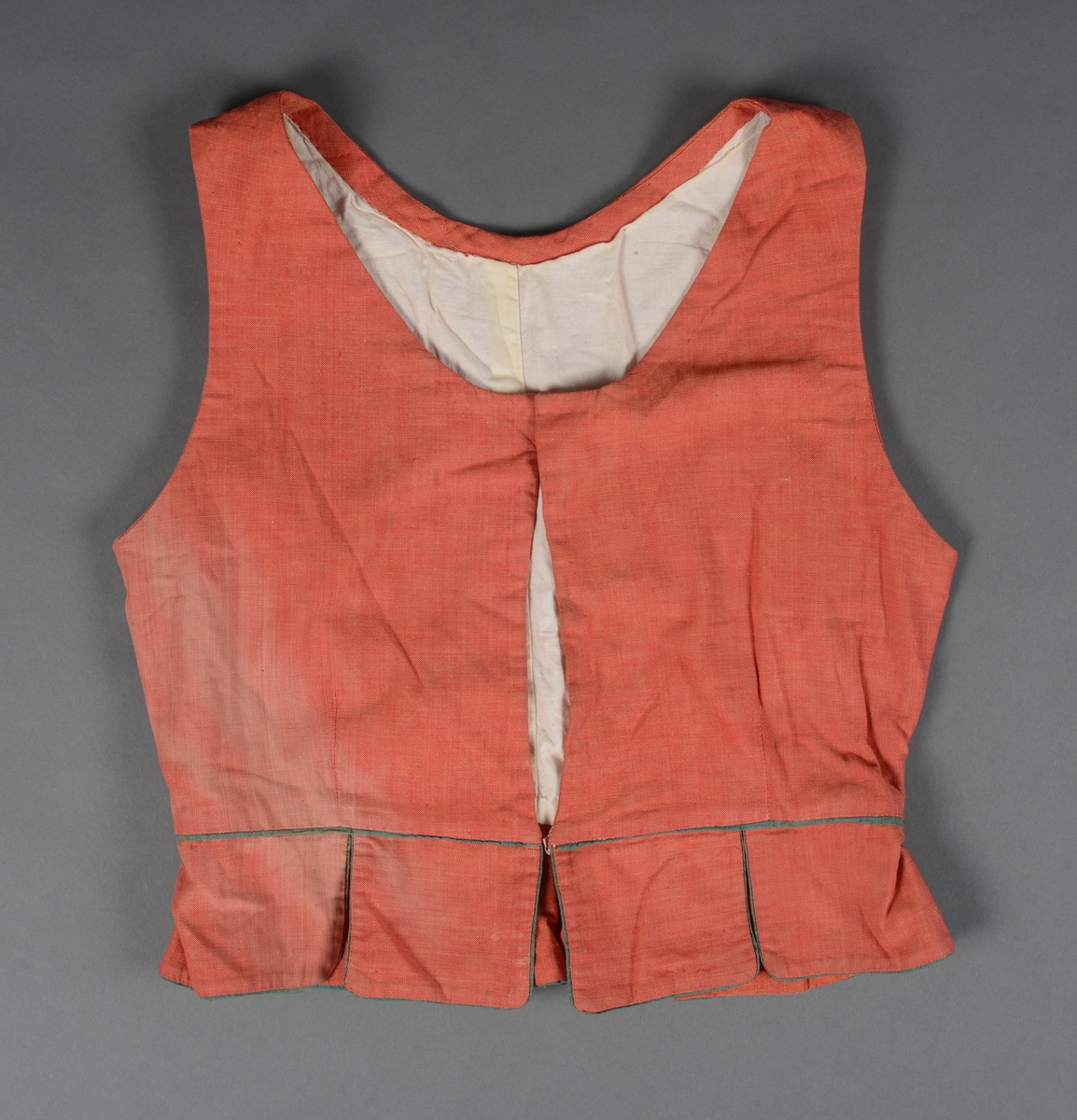 Tre-delt bunad:
A: Rødt liv med grønne kanter og hvitt bomulls fòr. Snittet er likt det som brukes til trønderbunaden. Skjøteliv med påsydd kappe og firkantete fliker i framkant. Det er sydd tittekant av grønt bomullstoff i livet og langs nedrekanten av skjøtet. Metallhekter til lukking.
B: Stakk av stripet bomullstoff i fargene brunt, rødt, gult, grønt og hvitt. Svakt rynket til linning. Lukkes med hekter og sekundært innsydd glidelås.
C: Stakk av samme snit og materiale som B. Linning med langsgående striper. Lukkes med hekter og tre trykknapper.
D: Skjorte i bomullstoff i primærsnitt. Påsydde skulderstykker, ståkrage og halssplitt med regels. Ermene er rynket til mansjetten. Mansjettene er brodert på grovere bomullstoff (sultan) med hardangersøm. Lukkes med metallhekter i messing.
Bunaden er i hovedsak maskinsydd. Som type er den trolig fra mellomkrigstida.