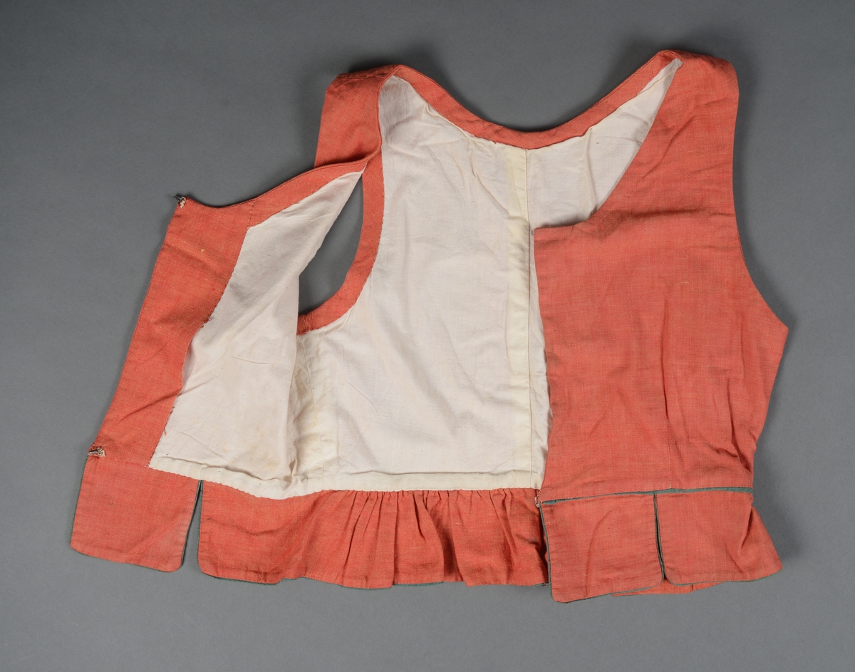 Tre-delt bunad:
A: Rødt liv med grønne kanter og hvitt bomulls fòr. Snittet er likt det som brukes til trønderbunaden. Skjøteliv med påsydd kappe og firkantete fliker i framkant. Det er sydd tittekant av grønt bomullstoff i livet og langs nedrekanten av skjøtet. Metallhekter til lukking.
B: Stakk av stripet bomullstoff i fargene brunt, rødt, gult, grønt og hvitt. Svakt rynket til linning. Lukkes med hekter og sekundært innsydd glidelås.
C: Stakk av samme snit og materiale som B. Linning med langsgående striper. Lukkes med hekter og tre trykknapper.
D: Skjorte i bomullstoff i primærsnitt. Påsydde skulderstykker, ståkrage og halssplitt med regels. Ermene er rynket til mansjetten. Mansjettene er brodert på grovere bomullstoff (sultan) med hardangersøm. Lukkes med metallhekter i messing.
Bunaden er i hovedsak maskinsydd. Som type er den trolig fra mellomkrigstida.