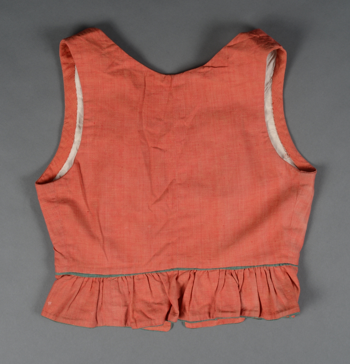 Tre-delt bunad:
A: Rødt liv med grønne kanter og hvitt bomulls fòr. Snittet er likt det som brukes til trønderbunaden. Skjøteliv med påsydd kappe og firkantete fliker i framkant. Det er sydd tittekant av grønt bomullstoff i livet og langs nedrekanten av skjøtet. Metallhekter til lukking.
B: Stakk av stripet bomullstoff i fargene brunt, rødt, gult, grønt og hvitt. Svakt rynket til linning. Lukkes med hekter og sekundært innsydd glidelås.
C: Stakk av samme snit og materiale som B. Linning med langsgående striper. Lukkes med hekter og tre trykknapper.
D: Skjorte i bomullstoff i primærsnitt. Påsydde skulderstykker, ståkrage og halssplitt med regels. Ermene er rynket til mansjetten. Mansjettene er brodert på grovere bomullstoff (sultan) med hardangersøm. Lukkes med metallhekter i messing.
Bunaden er i hovedsak maskinsydd. Som type er den trolig fra mellomkrigstida.