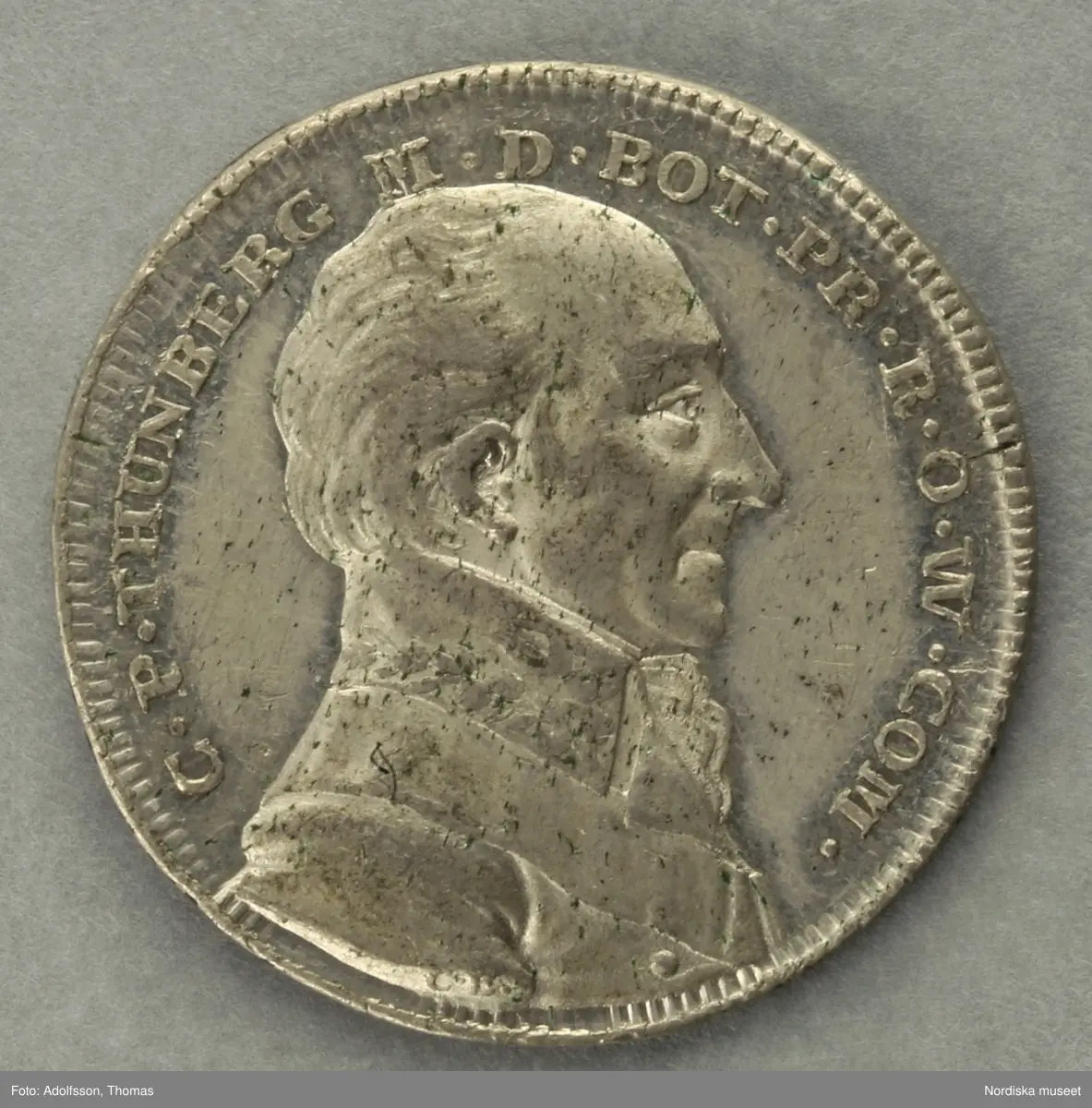 Huvudliggaren:
"I tenn. 
a) Öfver Gustaf II Adolf. Jmfr. Hildebrand, B. E. 'Sveriges och svenska konungahusets minnespenningar. Del I, sid 107, nr 9.b. Minnespenning, Gustaf II Adolf skänker Vasaättens arfvegods till Uppsala universitet och utfärdar nya priviligier 1624. Åtsidan konumgen bröstbild.
b) Jmfr. Hildebrand, B. E. 'Sveriges och svenska konungahusets minnespenningar. Del 2, sid 365, nr 80.. Medalj, för befrämjad vaccination. Åtsidan Karl XIV Johans bröstbild.
c) Jmfr. Hildebrand, B. E. 'Minnespenningar öfver enskilda svenska män och qvinnor, sid 321, nr 1. Minnespenning öfver Erik Karl Trafvenfelt.
d) Jmfr. Hildebrand, B. E. 'Minnespenningar öfver enskilda svenska män och qvinnor, sid 307, nr 1. Minnespenning öfver Karl Peter Thunberg.
G. ss. 32.642 [=G. af ingeniör Carl Vellenius i Norrköping gm. doktor A. Hazelius i Stockholm] 24/3 1882."