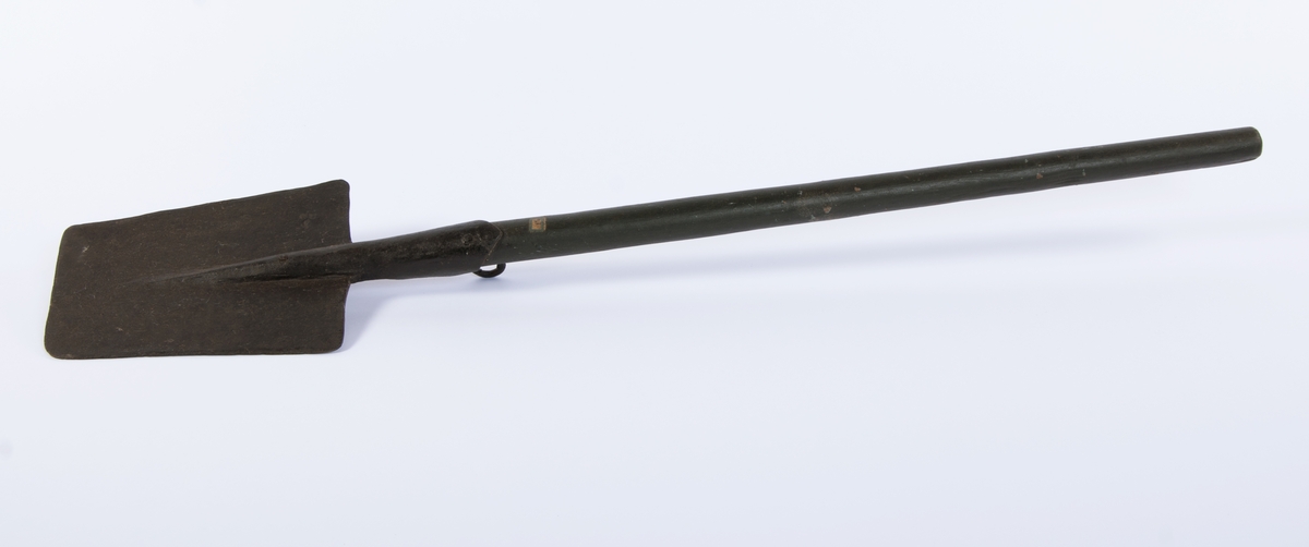 Langt, rett skaft stukket gjennom falen, ender i et spor på spadens iunderside. rett, trapesformet blad. Kraftig krok på skaftets underside, ved falen.
3 uidentifiserte stempler på bladets overside