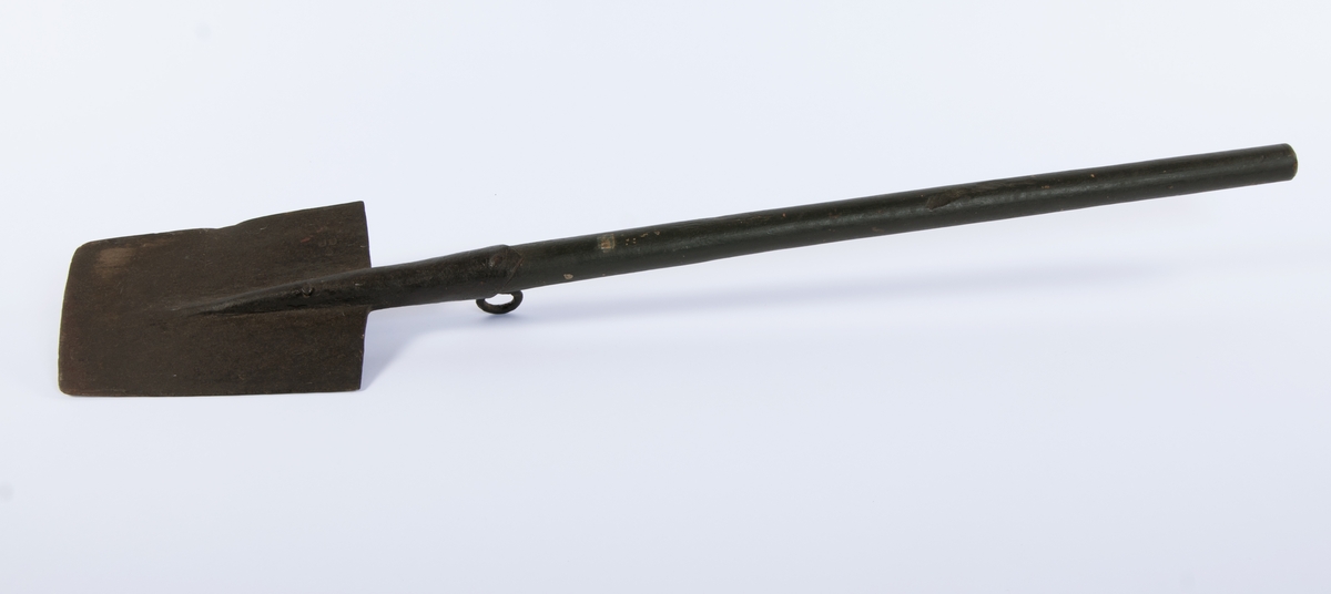 Langt, rett skaft stukket gjennom falen, ender i et spor på spadens iunderside. rett, trapesformet blad. Kraftig krok på skaftets underside, ved falen.
3 uidentifiserte stempler på bladets overside, mulig en kronet C (?)