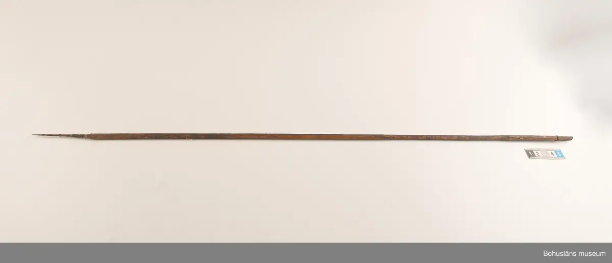 Ur handskrivna katalogen 1957-1958:
Båge m. 17 pilar, Afrika
Bågen a) L.103 cm; m. sträng av en vidja; i bågens ändar runda träkulor. Hel.
b-l, 3- kantiga m. smal svart fastsurrad träspets m. hullingar.
b-c, L. 72 och 71,2 cm; har blad infällda i ändan som styrfjädrar. Bladen saknas vid inventering 2022.
d-k, L. 75,5; 72; 71,8; 71,8; 71,6; 71,5; 76,6; 66 cm; lika b och c men saknar styrfjädrar;
k upptrasad i ändan.
l, L. 55,5; av ngt annan typ än föreg, har haft spets och styrfjädrar, vila saknas.
m-r, runda skaft, styrfjädrar, spetsen av järn m. hullingar (ej 791 m) och holk f. fastsättn.
L. 69; 68,1; 76,4; 65; 64,7; 61,3 cm;
("r" saknar spets; n och q saknar en hulling. "o" saknar 2 styrfjädrar; "p" saknar ena delen i "klykan" f. strängen)

Ur Knut Adrian Anderssons Katalog II 1916:
No 22, nr 7, 8 ,9 på etiketten i Elmer Göranssons samling. Båge av trä m. sena till sträng jämte 17 förgiftade pilar av två typer med hullingar. Från Mogala i Belgiska Congo.

Artikel i Bohusläningen måndagen den 1 november 1937, "Vittberesta bohusläningar berätta. Upplevelser under 30-årig vistelse i Belgiska Kongo. Kapen Elmer Göransson. Folk och sedvänjor under ekvatorns glödande sol."

UMFA54467:0588 visar porträtt på sjökapten Elmer Göransson i uniform med ett antal ordnar och utmärkelser. Fotograf Thure Nihlén, Uddevalla.