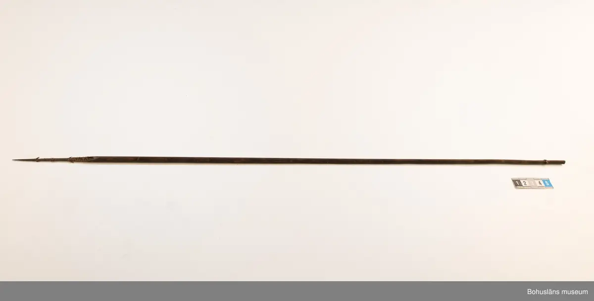 Ur handskrivna katalogen 1957-1958:
Båge m. 17 pilar, Afrika
Bågen a) L.103 cm; m. sträng av en vidja; i bågens ändar runda träkulor. Hel.
b-l, 3- kantiga m. smal svart fastsurrad träspets m. hullingar.
b-c, L. 72 och 71,2 cm; har blad infällda i ändan som styrfjädrar.
d-k, L. 75,5; 72; 71,8; 71,8; 71,6; 71,5; 76,6; 66 cm; lika b och c men saknar styrfjädrar;
k upptrasad i ändan.
l, L. 55,5; av ngt annan typ än föreg, har haft spets och styrfjädrar, vila saknas.
m-r, runda skaft, styrfjädrar, spetsen av järn m. hullingar (ej 791 m) och holk f. fastsättn.
L. 69; 68,1; 76,4; 65; 64,7; 61,3 cm;
("r" saknar spets; n och q saknar en hulling. "o" saknar 2 styrfjädrar; "p" saknar ena delen i "klykan" f. strängen)

Ur Knut Adrian Anderssons Katalog II 1916:
No 22, nr 7, 8 ,9 på etiketten i Elmer Göranssons samling. Båge av trä m. sena till sträng jämte 17 förgiftade pilar av två typer med hullingar. Från Mogala i Belgiska Congo.

Artikel i Bohusläningen måndagen den 1 november 1937, "Vittberesta bohusläningar berätta. Upplevelser under 30-årig vistelse i Belgiska Kongo. Kapen Elmer Göransson. Folk och sedvänjor under ekvatorns glödande sol."

UMFA54467:0588 visar porträtt på sjökapten Elmer Göransson i uniform med ett antal ordnar och utmärkelser. Fotograf Thure Nihlén, Uddevalla.
