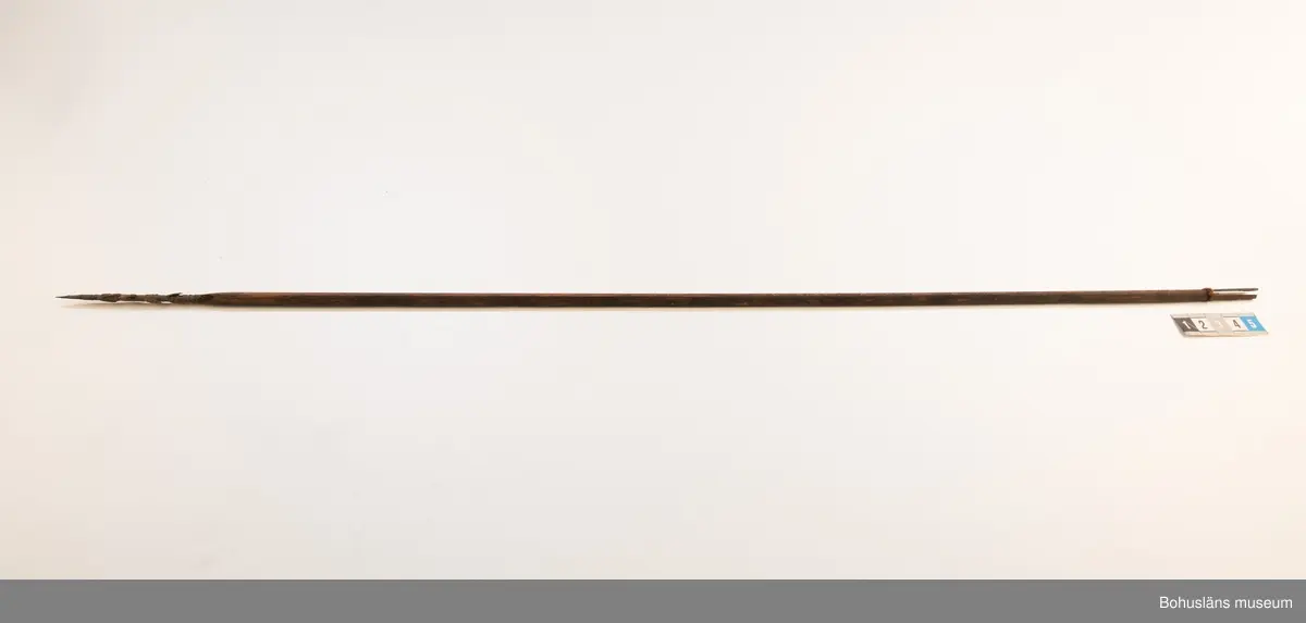 H: pispetsen är till större delen täckt av en torkad massa.
Ur handskrivna katalogen 1957-1958:
Båge m. 17 pilar, Afrika
Bågen a) L.103 cm; m. sträng av en vidja; i bågens ändar runda träkulor. Hel.
b-l, 3- kantiga m. smal svart fastsurrad träspets m. hullingar.
b-c, L. 72 och 71,2 cm; har blad infällda i ändan som styrfjädrar.
d-k, L. 75,5; 72; 71,8; 71,8; 71,6; 71,5; 76,6; 66 cm; lika b och c men saknar styrfjädrar;
k upptrasad i ändan.
l, L. 55,5; av ngt annan typ än föreg, har haft spets och styrfjädrar, vila saknas.
m-r, runda skaft, styrfjädrar, spetsen av järn m. hullingar (ej 791 m) och holk f. fastsättn.
L. 69; 68,1; 76,4; 65; 64,7; 61,3 cm;
("r" saknar spets; n och q saknar en hulling. "o" saknar 2 styrfjädrar; "p" saknar ena delen i "klykan" f. strängen)

Ur Knut Adrian Anderssons Katalog II 1916:
No 22, nr 7, 8 ,9 på etiketten i Elmer Göranssons samling. Båge av trä m. sena till sträng jämte 17 förgiftade pilar av två typer med hullingar. Från Mogala i Belgiska Congo.

Artikel i Bohusläningen måndagen den 1 november 1937, "Vittberesta bohusläningar berätta. Upplevelser under 30-årig vistelse i Belgiska Kongo. Kapen Elmer Göransson. Folk och sedvänjor under ekvatorns glödande sol."

UMFA54467:0588 visar porträtt på sjökapten Elmer Göransson i uniform med ett antal ordnar och utmärkelser. Fotograf Thure Nihlén, Uddevalla.