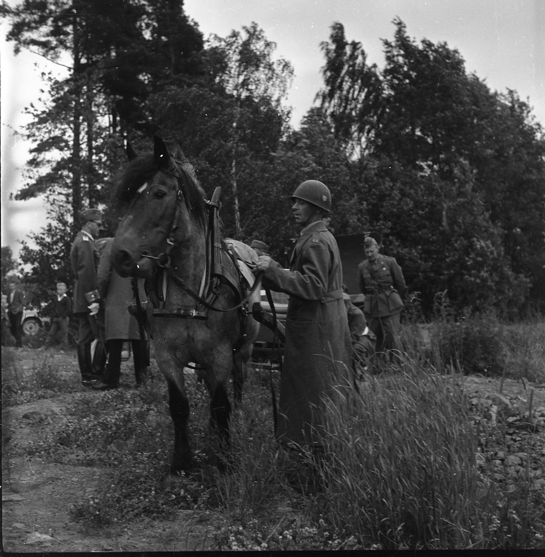 Män i militär uniform intill en häst. Spex i samband med Osse Gustafssons 60-årsdag.