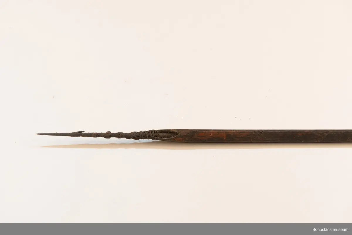 K: Sprucken i bakre änden.

Ur handskrivna katalogen 1957-1958:
Båge m. 17 pilar, Afrika
Bågen a) L.103 cm; m. sträng av en vidja; i bågens ändar runda träkulor. Hel.
b-l, 3- kantiga m. smal svart fastsurrad träspets m. hullingar.
b-c, L. 72 och 71,2 cm; har blad infällda i ändan som styrfjädrar.
d-k, L. 75,5; 72; 71,8; 71,8; 71,6; 71,5; 76,6; 66 cm; lika b och c men saknar styrfjädrar;
k upptrasad i ändan.
l, L. 55,5; av ngt annan typ än föreg, har haft spets och styrfjädrar, vila saknas.
m-r, runda skaft, styrfjädrar, spetsen av järn m. hullingar (ej 791 m) och holk f. fastsättn.
L. 69; 68,1; 76,4; 65; 64,7; 61,3 cm;
("r" saknar spets; n och q saknar en hulling. "o" saknar 2 styrfjädrar; "p" saknar ena delen i "klykan" f. strängen)

Ur Knut Adrian Anderssons Katalog II 1916:
No 22, nr 7, 8 ,9 på etiketten i Elmer Göranssons samling. Båge av trä m. sena till sträng jämte 17 förgiftade pilar av två typer med hullingar. Från Mogala i Belgiska Congo.

Artikel i Bohusläningen måndagen den 1 november 1937, "Vittberesta bohusläningar berätta. Upplevelser under 30-årig vistelse i Belgiska Kongo. Kapen Elmer Göransson. Folk och sedvänjor under ekvatorns glödande sol."

UMFA54467:0588 visar porträtt på sjökapten Elmer Göransson i uniform med ett antal ordnar och utmärkelser. Fotograf Thure Nihlén, Uddevalla.