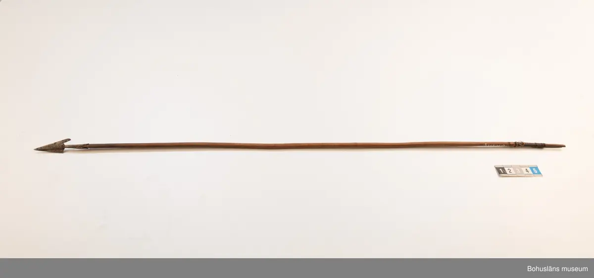 Ur handskrivna katalogen 1957-1958:
Båge m. 17 pilar, Afrika
Bågen a) L.103 cm; m. sträng av en vidja; i bågens ändar runda träkulor. Hel.
b-l, 3- kantiga m. smal svart fastsurrad träspets m. hullingar.
b-c, L. 72 och 71,2 cm; har blad infällda i ändan som styrfjädrar.
d-k, L. 75,5; 72; 71,8; 71,8; 71,6; 71,5; 76,6; 66 cm; lika b och c men saknar styrfjädrar;
k upptrasad i ändan.
l, L. 55,5; av ngt annan typ än föreg, har haft spets och styrfjädrar, vila saknas.
m-r, runda skaft, styrfjädrar, spetsen av järn m. hullingar (ej 791 m) och holk f. fastsättn.
L. 69; 68,1; 76,4; 65; 64,7; 61,3 cm;
("r" saknar spets; n och q saknar en hulling. "o" saknar 2 styrfjädrar; "p" saknar ena delen i "klykan" f. strängen)
Q: saknar styrfjädrar och har något fragmenterad pilspets.

Ur Knut Adrian Anderssons Katalog II 1916:
No 22, nr 7, 8 ,9 på etiketten i Elmer Göranssons samling. Båge av trä m. sena till sträng jämte 17 förgiftade pilar av två typer med hullingar. Från Mogala i Belgiska Congo.

Artikel i Bohusläningen måndagen den 1 november 1937, "Vittberesta bohusläningar berätta. Upplevelser under 30-årig vistelse i Belgiska Kongo. Kapen Elmer Göransson. Folk och sedvänjor under ekvatorns glödande sol."

UMFA54467:0588 visar porträtt på sjökapten Elmer Göransson i uniform med ett antal ordnar och utmärkelser. Fotograf Thure Nihlén, Uddevalla.