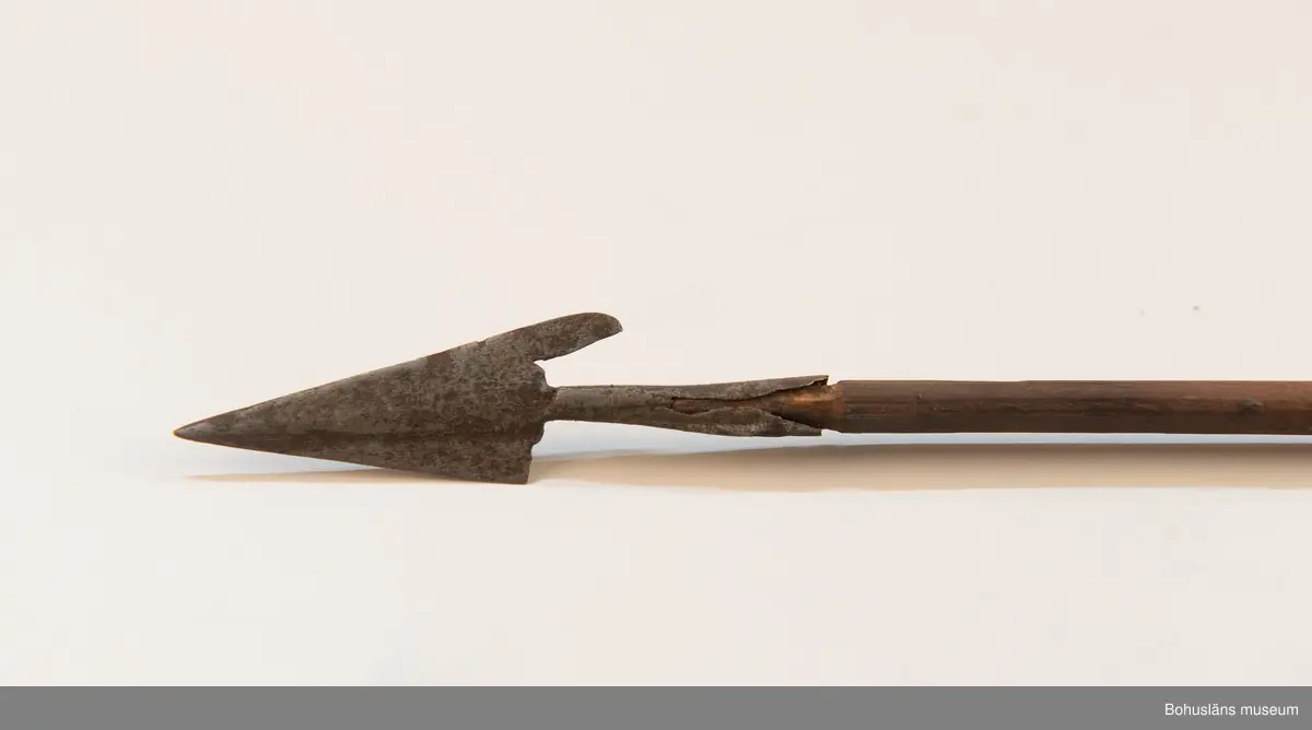 Ur handskrivna katalogen 1957-1958:
Båge m. 17 pilar, Afrika
Bågen a) L.103 cm; m. sträng av en vidja; i bågens ändar runda träkulor. Hel.
b-l, 3- kantiga m. smal svart fastsurrad träspets m. hullingar.
b-c, L. 72 och 71,2 cm; har blad infällda i ändan som styrfjädrar.
d-k, L. 75,5; 72; 71,8; 71,8; 71,6; 71,5; 76,6; 66 cm; lika b och c men saknar styrfjädrar;
k upptrasad i ändan.
l, L. 55,5; av ngt annan typ än föreg, har haft spets och styrfjädrar, vila saknas.
m-r, runda skaft, styrfjädrar, spetsen av järn m. hullingar (ej 791 m) och holk f. fastsättn.
L. 69; 68,1; 76,4; 65; 64,7; 61,3 cm;
("r" saknar spets; n och q saknar en hulling. "o" saknar 2 styrfjädrar; "p" saknar ena delen i "klykan" f. strängen)
Q: saknar styrfjädrar och har något fragmenterad pilspets.

Ur Knut Adrian Anderssons Katalog II 1916:
No 22, nr 7, 8 ,9 på etiketten i Elmer Göranssons samling. Båge av trä m. sena till sträng jämte 17 förgiftade pilar av två typer med hullingar. Från Mogala i Belgiska Congo.

Artikel i Bohusläningen måndagen den 1 november 1937, "Vittberesta bohusläningar berätta. Upplevelser under 30-årig vistelse i Belgiska Kongo. Kapen Elmer Göransson. Folk och sedvänjor under ekvatorns glödande sol."

UMFA54467:0588 visar porträtt på sjökapten Elmer Göransson i uniform med ett antal ordnar och utmärkelser. Fotograf Thure Nihlén, Uddevalla.