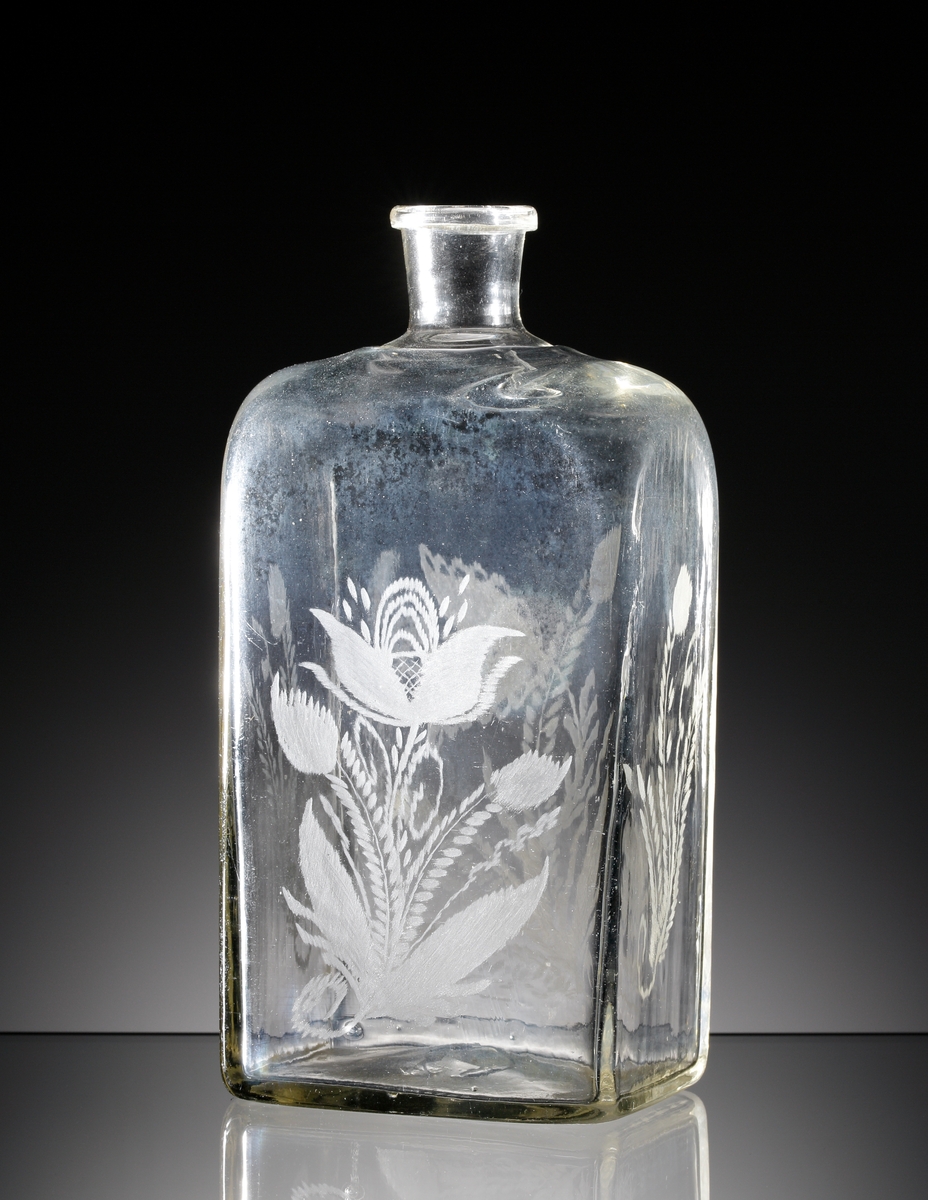 Brännvinsflaska.
Beskrivning: Rektangulär botten. Graverade blommor.
Färg: Svagt brungult klarglas.
Inskrivet i huvudkatalogen tidigast 1935.
M 6781 och M 16615 tillhör antagligen samma verkstad. Tillverkat under mitten eller senare delen av 1800-talet. Troligen tillverkat på Reijmyre glasbruk.

Litteratur:
Se Nisbeth och Fogelberg, "Reijmyre Glasbruk", fig. 40, "Brännvinsflaska", daterad 1843 (gaveldekor).
Funktion: Brännvinsflaska