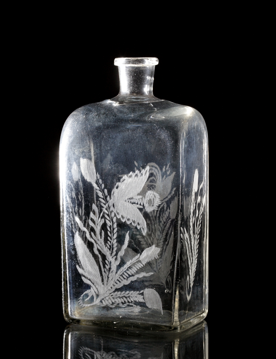 Brännvinsflaska.
Beskrivning: Rektangulär botten. Graverade blommor.
Färg: Svagt brungult klarglas.
Inskrivet i huvudkatalogen tidigast 1935.
M 6781 och M 16615 tillhör antagligen samma verkstad. Tillverkat under mitten eller senare delen av 1800-talet. Troligen tillverkat på Reijmyre glasbruk.

Litteratur:
Se Nisbeth och Fogelberg, "Reijmyre Glasbruk", fig. 40, "Brännvinsflaska", daterad 1843 (gaveldekor).
Funktion: Brännvinsflaska