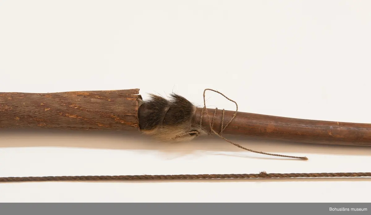 Ur handskrivna katalogen 1957-1958:
Praktbåge, Afrika
L. 137 cm; mkt hårt trä; bågens mittparti är klätt m. skinn, som skyddas av ett barkfodral; sträng av hampa. Hel.

Lappkatalog: 9
