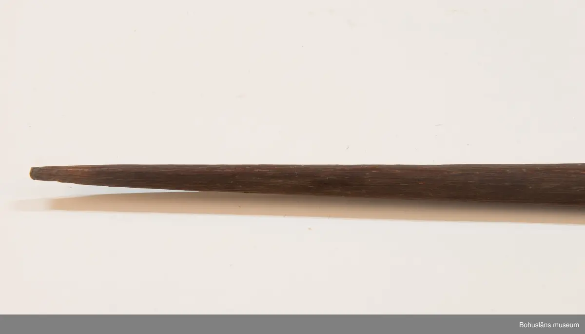 Ur handskrivna katalogen 1957-1958:
Pilbåge, Kongo, Afrika
L. 206,5 cm; på ena sidan svart, på andra rödbrun m. 2 svarta linjer i mitten. Strängen trasig, f. övr. hel.
Sträng saknas vid inventering 20220607.

Lappkatalog: 9