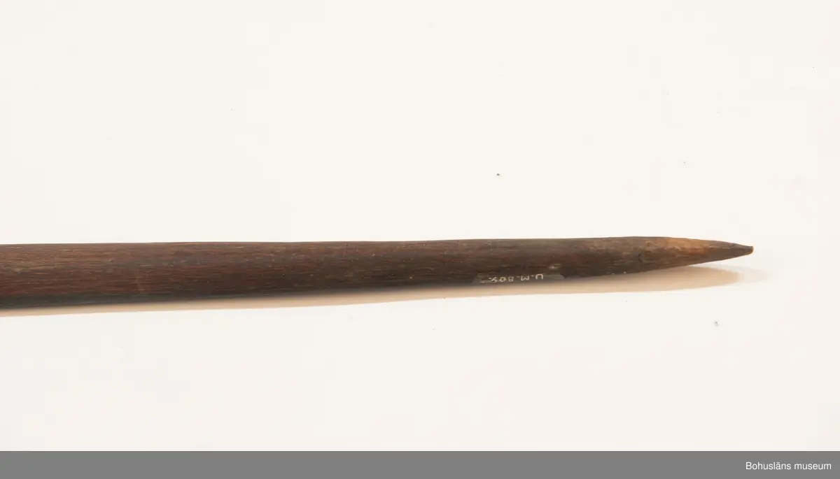 Ur handskrivna katalogen 1957-1958:
Pilbåge, Kongo, Afrika
L. 206,5 cm; på ena sidan svart, på andra rödbrun m. 2 svarta linjer i mitten. Strängen trasig, f. övr. hel.
Sträng saknas vid inventering 20220607.

Lappkatalog: 9