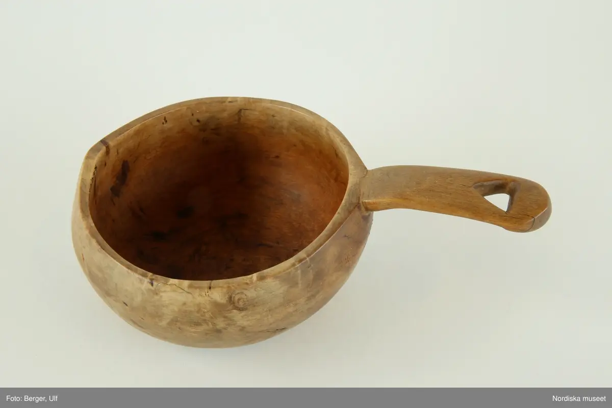 Huvudliggaren:
"Drickskopa 'kukse' av masurbjörk, hjärtformat urtag i skaftet. L 14 cm (med skaft), Diam ca 8 cm. I[nköpt] 11/3 1957 [från] Fru Maja Wickboms dödsbo gm major O. Wickbom, Stockholm jämte 254.083 - 098 [...]. [Brukningsort:] Lappland Torne lappmark."