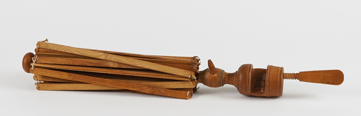 Paraplyforma, samanleggbart hespetre/ garnvinde til å feste til (bord)plate. Sett saman av flate spiler som er klinka ihop. "Stamma" er dreia. Ei kule med skrue er set inn på stamma, og kan flyttast og festas slik at vidden på garnvinda kan justeras trinnlaust, og tilpassas hesper i ulike storleikar. Nedst er det ei tvinge til å feste garnvinda i bordplater.