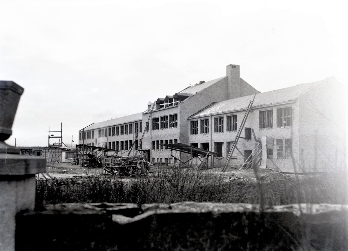 Hagaskolan i Varberg under uppbyggnad i kv Orren. Bild 1 visar en byggnad med färdigställd fasad, medan de på bild 2 Karl Fredrik Olsson var redaktör (ca 1935-1965) på Hallandsposten så bilderna har troligen varit publicerade i tidningen.