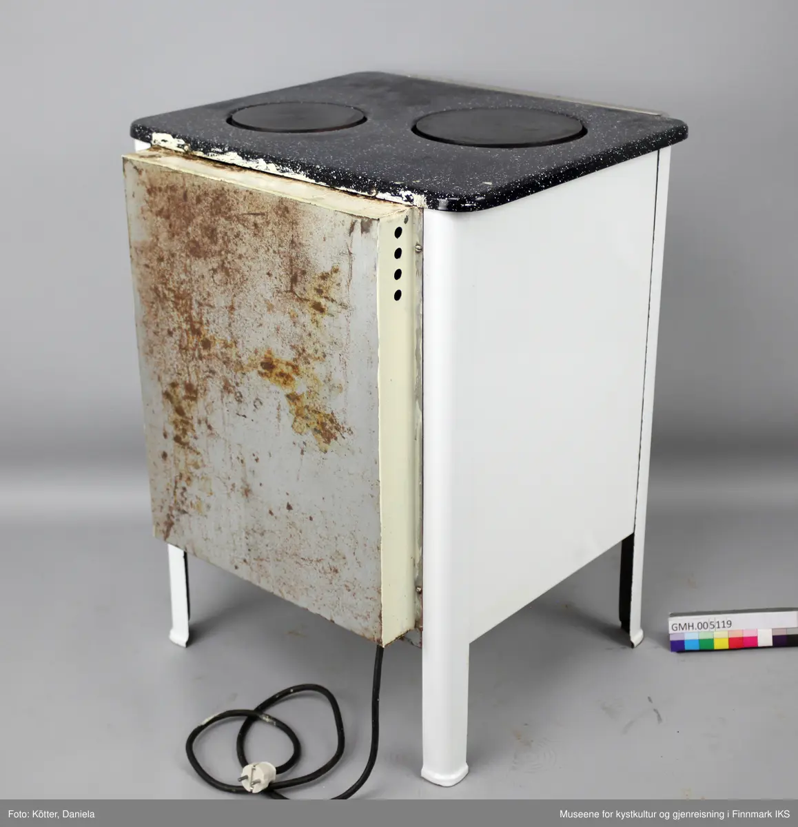 Den elektriske komfyren "Diamant PK 2" har to kokeplater og en stekeovn. Apparatet står på fire ben og har fire vrideknapper, en for hver plate, samt for over- og undervarme i ovnen. På ovnsdøra er det en rund termometer som viser temperaturen i ovnen. I ovnen er det to lave og et dypt stekebrett. Foran på toppen er det en sølvfarget stang.