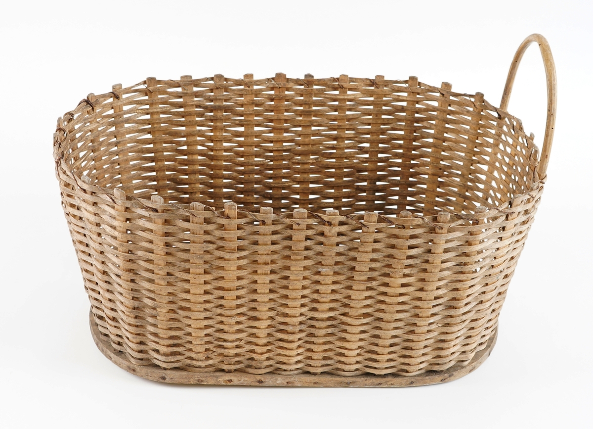 Korg, fletta. Oval treplate som botn. Stavar i tre sett inn i plata og spikra fast frå sida. Flettematerialet (flatt tre "spon") er fletta over/under stolpane. Det har vore hank i kvar kortende, men den er knekt av i eine. Forsterka med metallstreng i øvre kant. Rette sider. Skrånar noko innover ned mot bontnen.