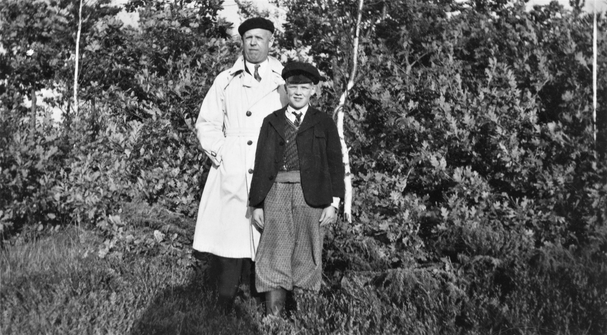 Axel och Bengt Selvén står ute bland lövträd och -buskar. Axel är farbror till Bengt och han bodde i Cleveland USA i flera år, men flyttade hem till Dagsås igen. På baksidan av fotografiet finns en stor amerikansk stämpel med dateringen 12 november 1933 eller 1938, samt fotofirman Booth Quality Photo CO, Cleveland, Ohio.