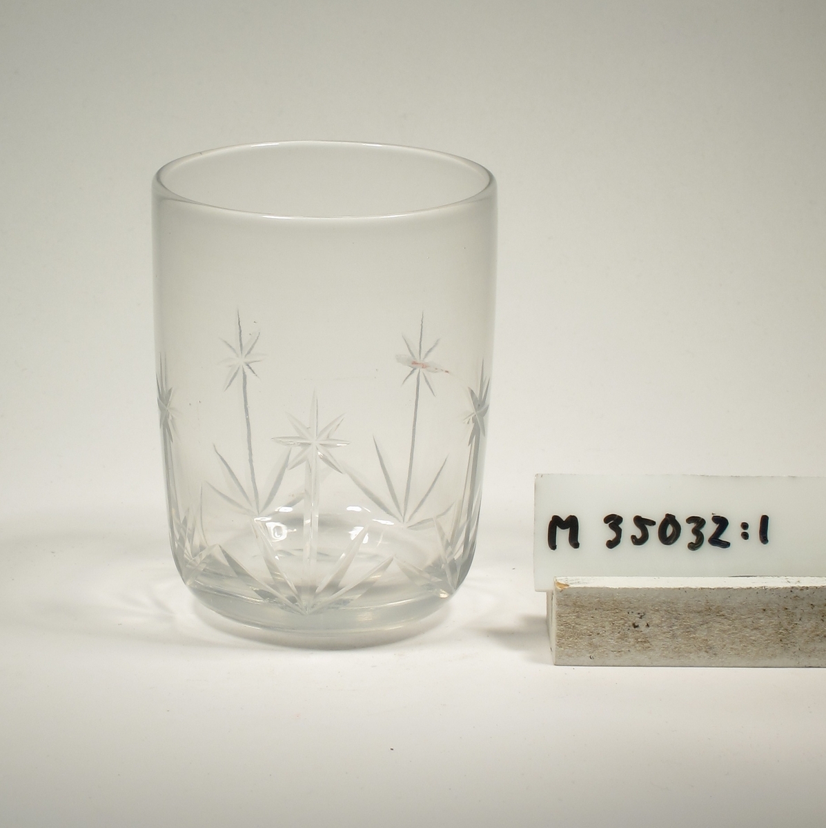 Cylinderformat, avrundat mot botten. Skärslipad blomdekor.