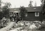 Turistföreningens härbärge i Porjus. Exteriör, en samling män och kvinnor poserar på trappan.